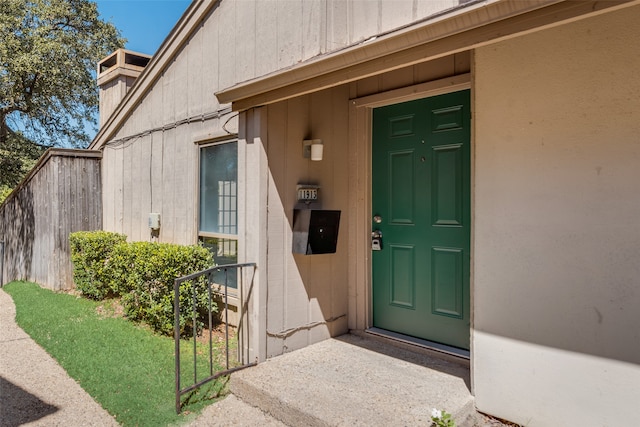 property entrance with a lawn