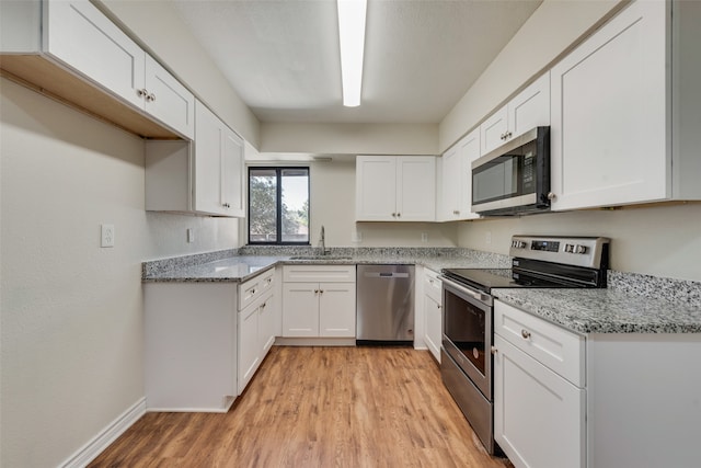 kitchen featuring white cabinets, light hardwood / wood-style flooring, light stone countertops, stainless steel appliances, and sink