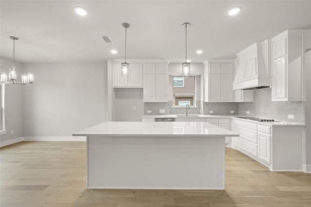 kitchen with light hardwood / wood-style flooring, white cabinets, and a center island