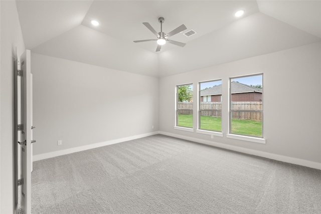 carpeted spare room with ceiling fan and vaulted ceiling