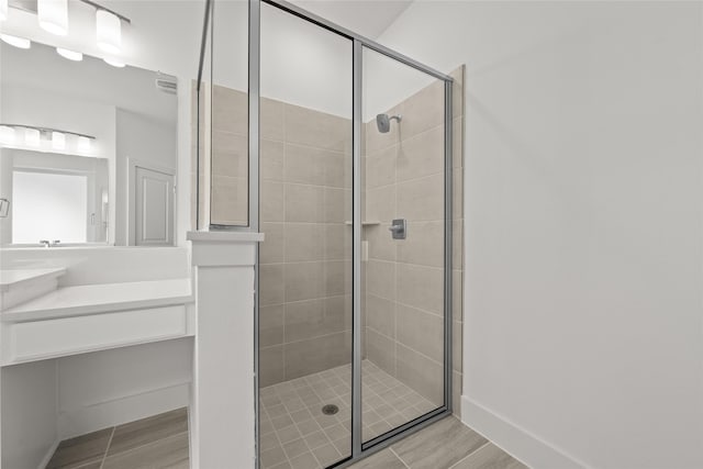 bathroom with vanity, a shower with shower door, and hardwood / wood-style floors