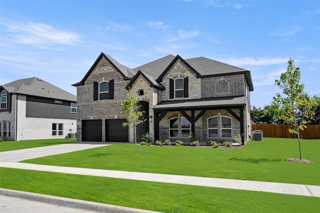 view of front of property featuring a garage, central AC unit, and a front lawn