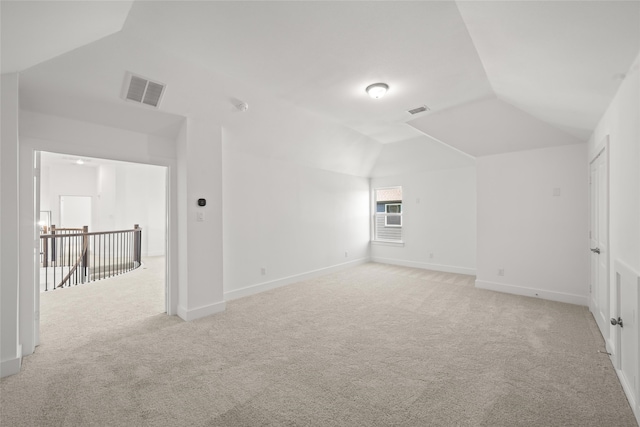 additional living space featuring light carpet and lofted ceiling