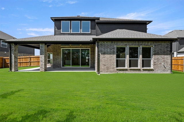 rear view of house with a lawn and a patio