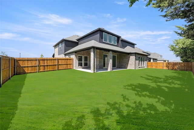 rear view of property with a yard and a patio