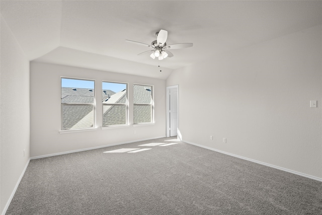 carpeted spare room with ceiling fan and vaulted ceiling