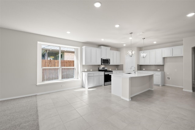 kitchen featuring sink, a center island with sink, white cabinets, and stainless steel appliances