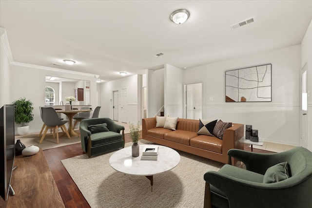 living room with dark hardwood / wood-style floors and crown molding