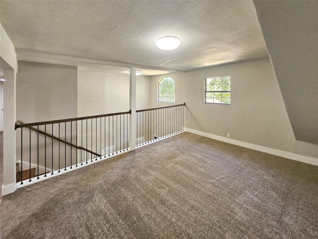 carpeted spare room featuring a textured ceiling