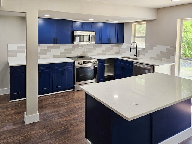 kitchen with a healthy amount of sunlight, stainless steel appliances, and blue cabinetry