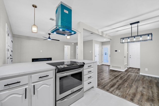 kitchen featuring decorative light fixtures, island exhaust hood, white cabinetry, ceiling fan, and stainless steel range with electric cooktop