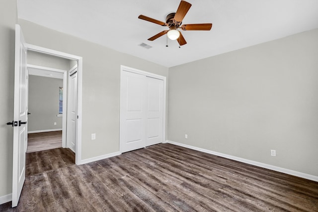 unfurnished bedroom with ceiling fan, a closet, and dark hardwood / wood-style flooring