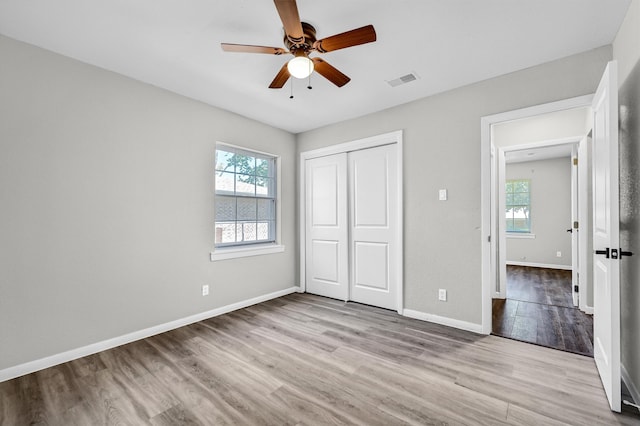 unfurnished bedroom featuring light wood-type flooring, a closet, and ceiling fan