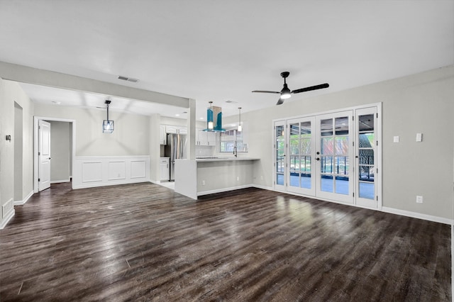 unfurnished living room with french doors, dark hardwood / wood-style flooring, sink, and ceiling fan