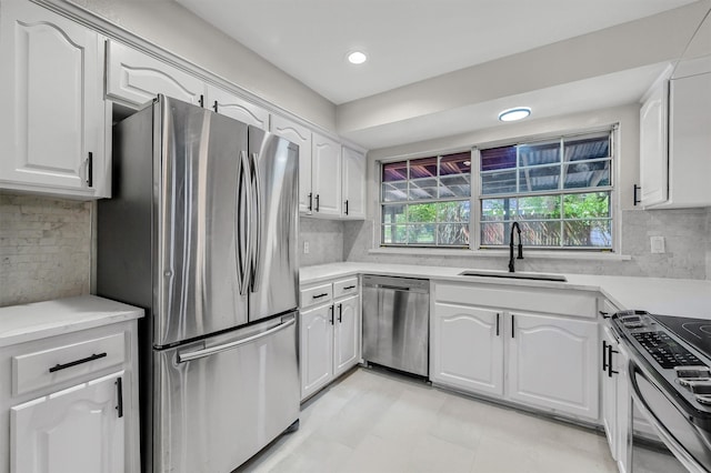 kitchen featuring appliances with stainless steel finishes, backsplash, white cabinetry, and sink