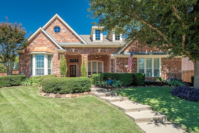 view of front facade featuring brick siding and a front lawn