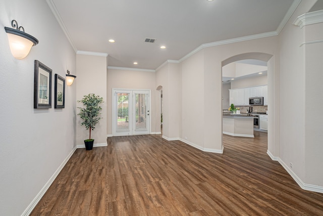 empty room featuring dark wood-type flooring and crown molding