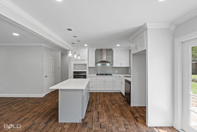 kitchen with white cabinetry, black appliances, a kitchen island, decorative light fixtures, and wall chimney exhaust hood