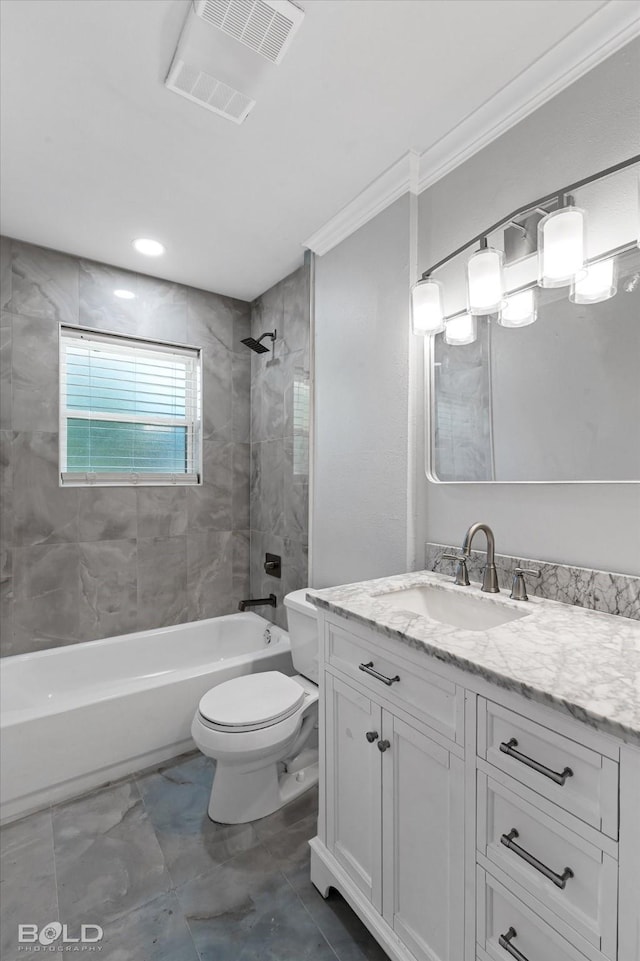 full bathroom featuring tiled shower / bath combo, vanity, crown molding, and toilet