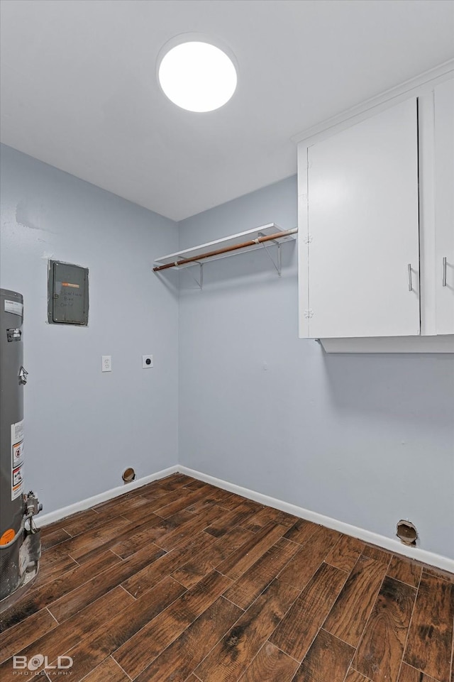 clothes washing area with water heater, electric panel, cabinets, and hookup for an electric dryer