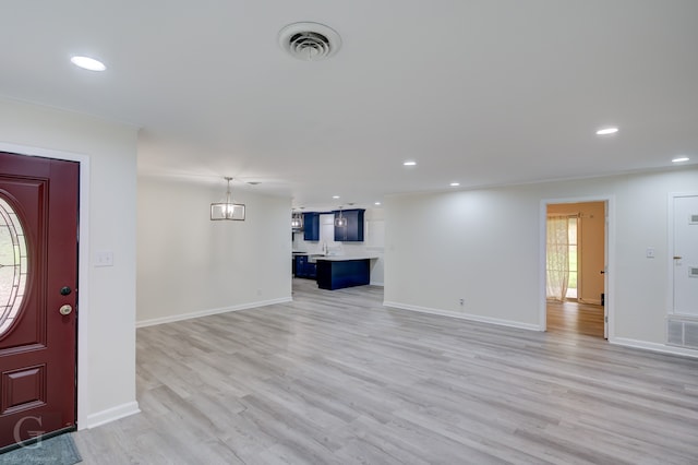 interior space with an inviting chandelier, light hardwood / wood-style floors, and sink