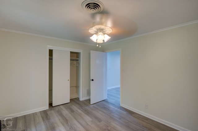 unfurnished bedroom with ceiling fan, ornamental molding, a closet, and light hardwood / wood-style floors