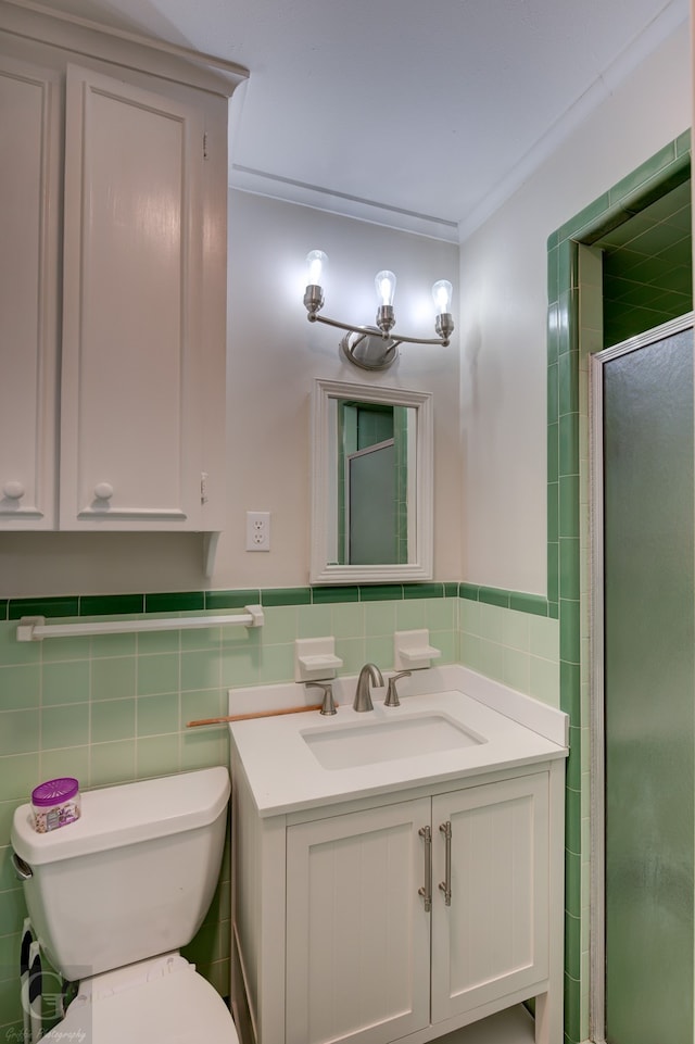 bathroom featuring tile walls, a shower with shower door, ornamental molding, vanity, and toilet