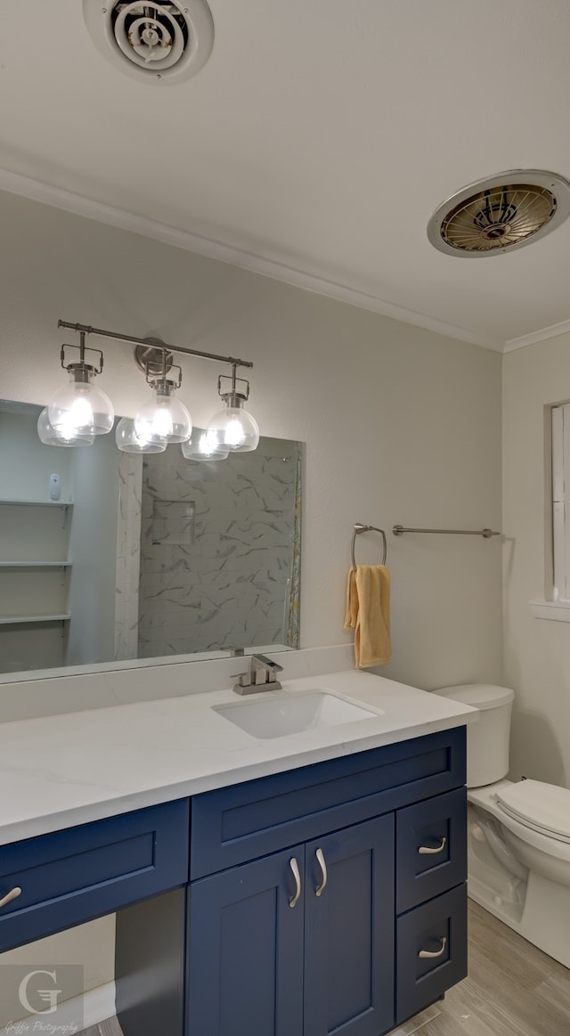 bathroom with crown molding, toilet, vanity, and hardwood / wood-style floors