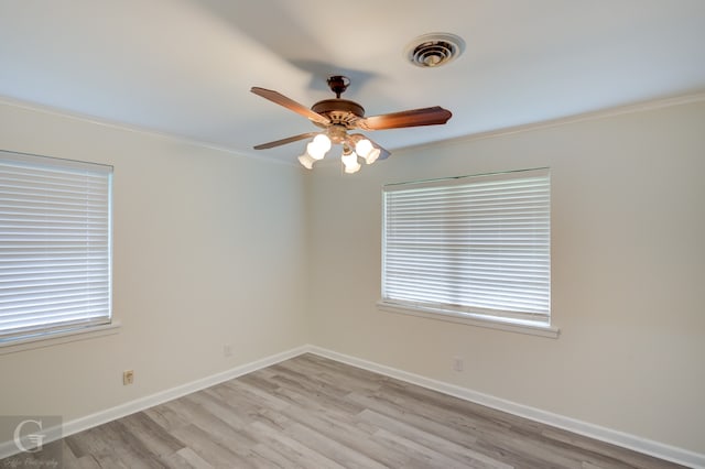 spare room with light wood-type flooring, crown molding, ceiling fan, and plenty of natural light