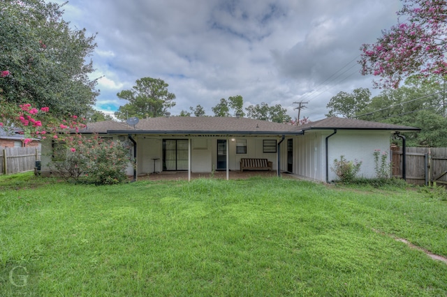 rear view of property featuring a yard