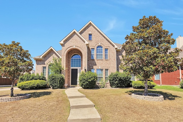 traditional home with brick siding and a front yard