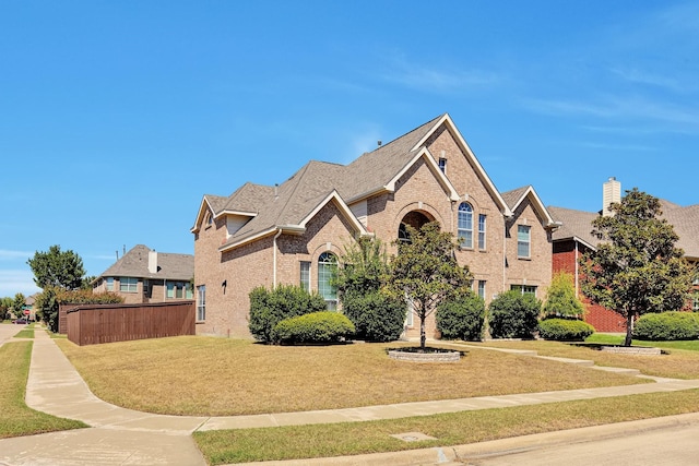 view of front of house featuring a front yard and brick siding