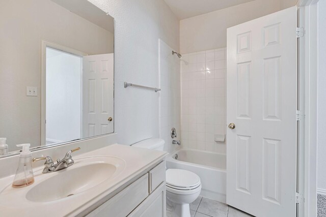 full bathroom with tiled shower / bath, vanity, toilet, and tile patterned floors