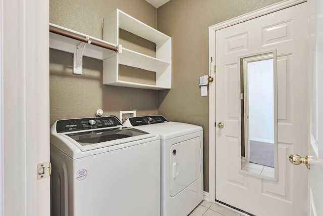 laundry room with washing machine and clothes dryer and light tile patterned floors