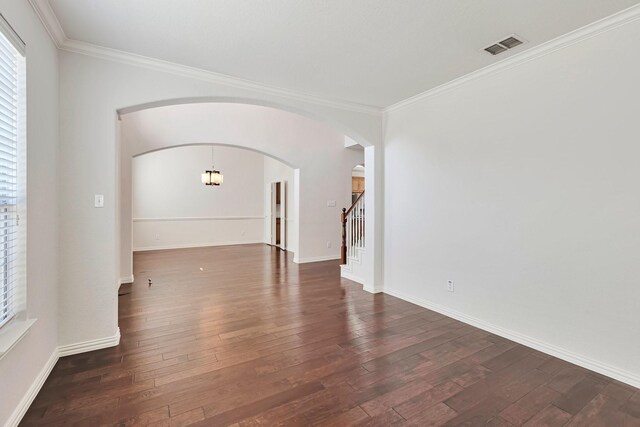 empty room with dark hardwood / wood-style floors and ornamental molding