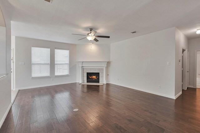 unfurnished living room with ceiling fan, a fireplace, and dark hardwood / wood-style floors