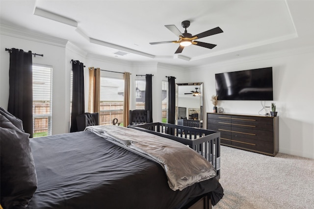 bedroom featuring light colored carpet, crown molding, ceiling fan, and a tray ceiling