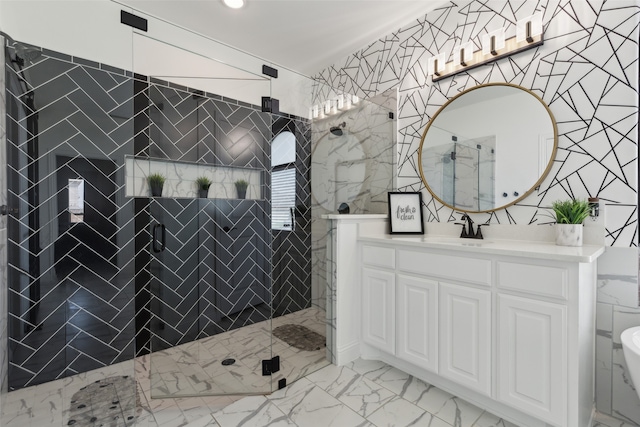 bathroom featuring tiled shower, vanity, and tile walls