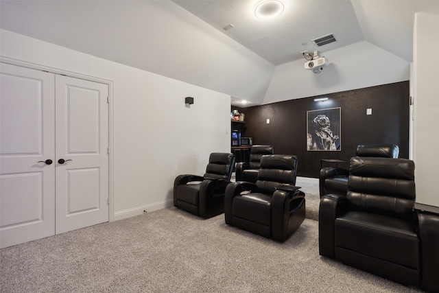 home theater room with light carpet and vaulted ceiling