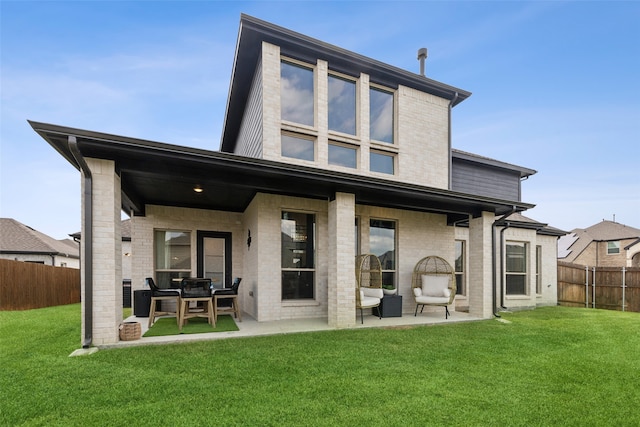 rear view of property featuring a yard and a patio