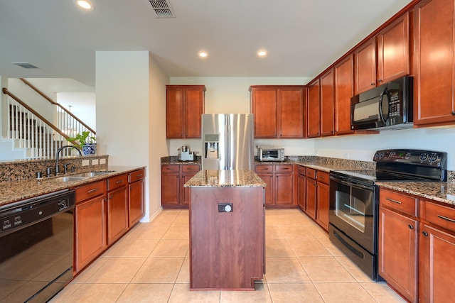 kitchen with a center island with sink, dishwasher, a tile fireplace, light hardwood / wood-style floors, and stainless steel refrigerator with ice dispenser