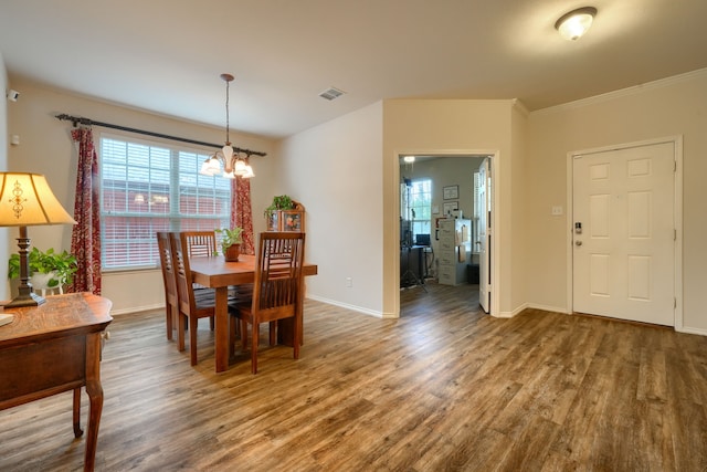 dining area featuring hardwood / wood-style flooring, a healthy amount of sunlight, and ceiling fan with notable chandelier