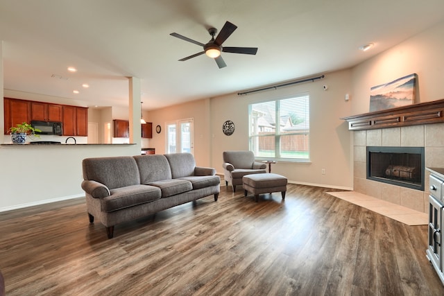 living room with ceiling fan, light wood-type flooring, and a fireplace