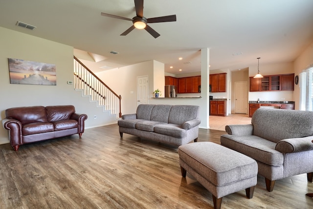 living room with ceiling fan, dark hardwood / wood-style flooring, and a tile fireplace