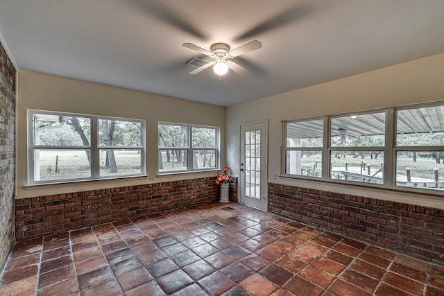 unfurnished sunroom with ceiling fan and a wealth of natural light