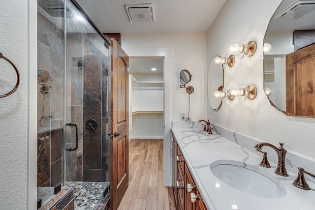 bathroom featuring vanity, an enclosed shower, and wood-type flooring