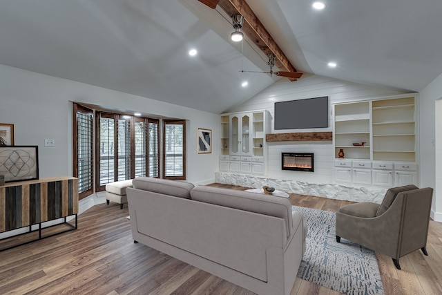 living room with built in features, vaulted ceiling with beams, and hardwood / wood-style flooring