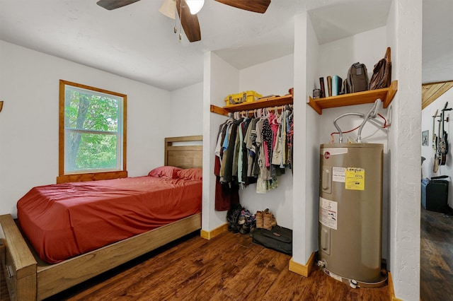 bedroom with electric water heater, wood-type flooring, ceiling fan, and a closet