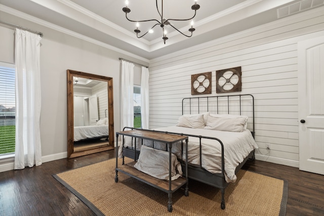 bedroom with crown molding, dark hardwood / wood-style floors, and an inviting chandelier