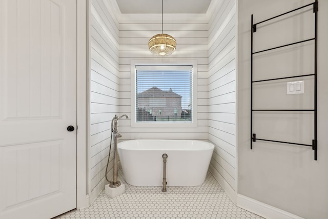 bathroom with a tub to relax in, wood walls, and tile patterned flooring